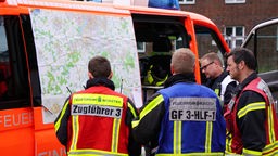 Feuerwehrmänner aus Münster sehen sich eine Karte an.